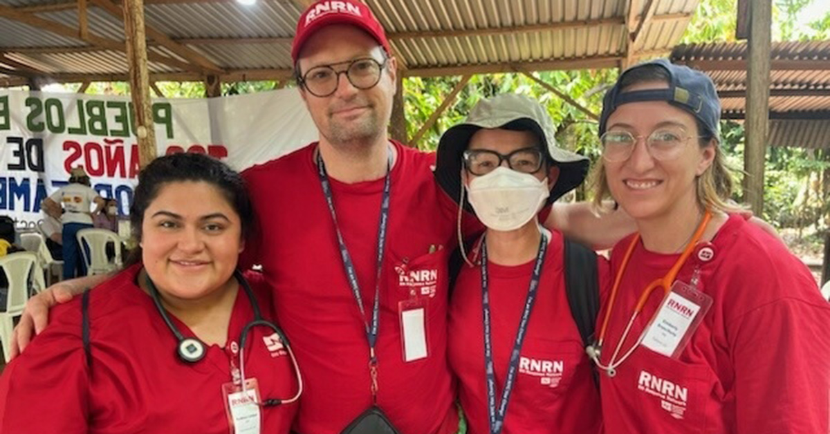 Four nurses in red scrubs in rural area of Guatemala 