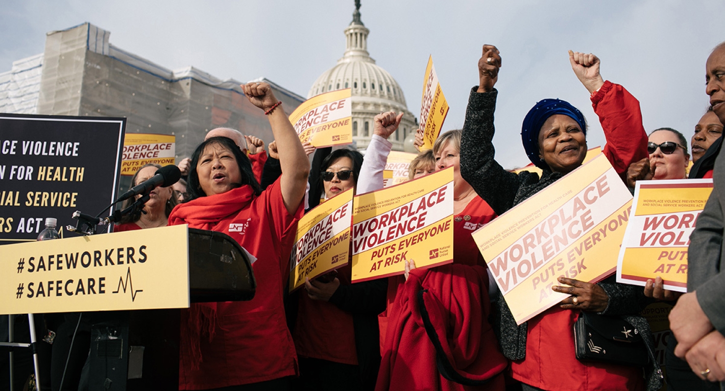 Group of nurses outside U.S. capitol building with raised fists