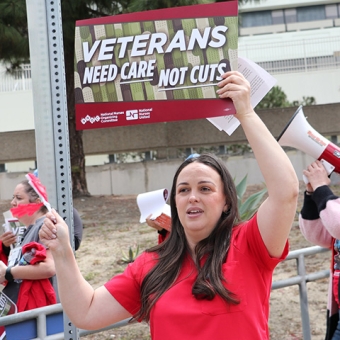 Nurse holding signs "Veterans Need Care Not Cuts"