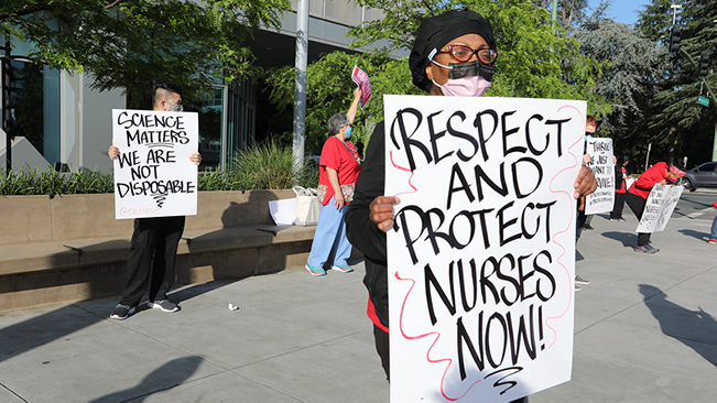 Nurses hold signs "Protect Nurses"
