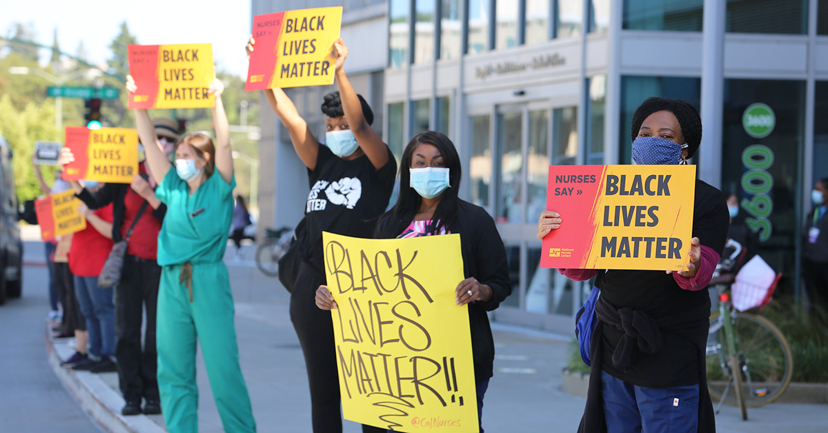 Nurses outside hospital hold signs "Black Lives Matter"