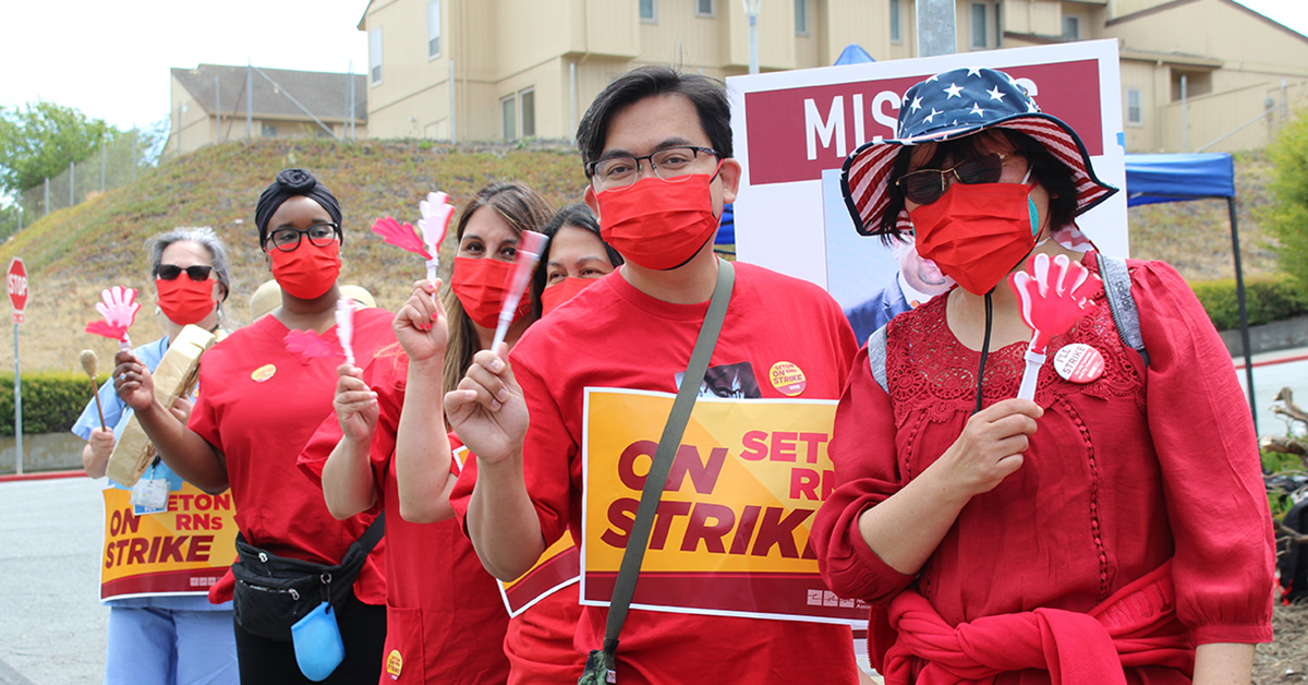 Group of nurses outside hold signs "On Strike"