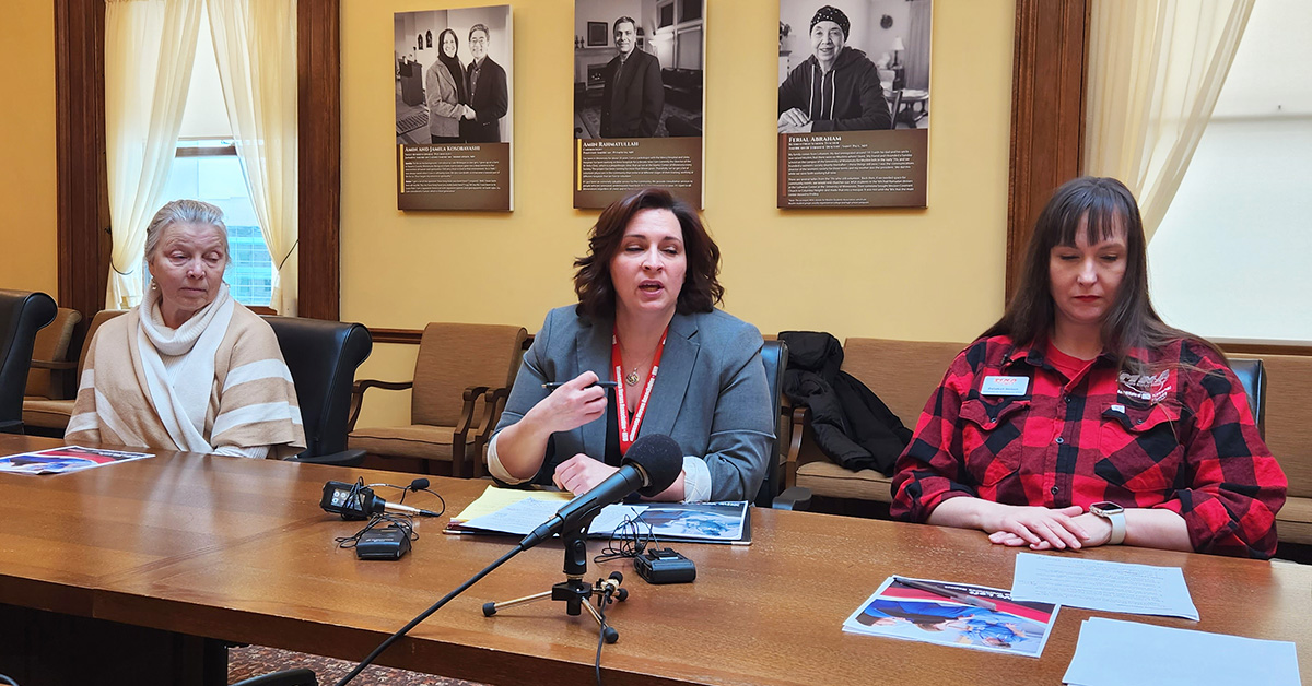 Three nurses sitting at table in front of microphones