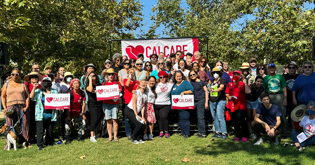 Large group of people standing in front of CalCare banner