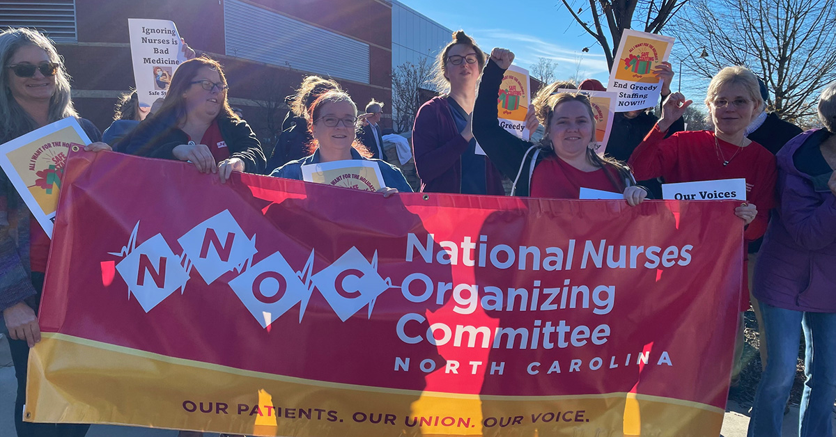 Group of nurses outside hospital holding banner "National Nurses Organizing Committee North Carolina"