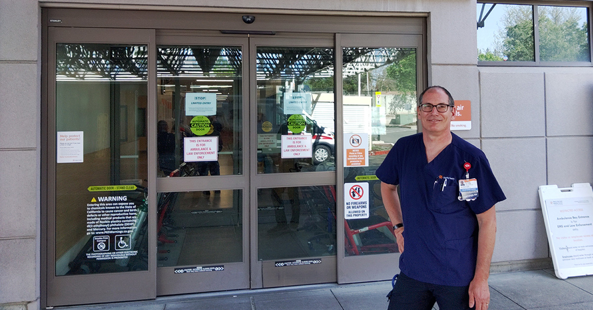 Frank Bartuska, an RN, standing in front of hospital entrance
