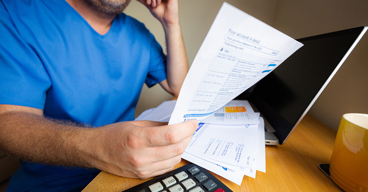 Nurse at desk holding a looking at bill/contract
