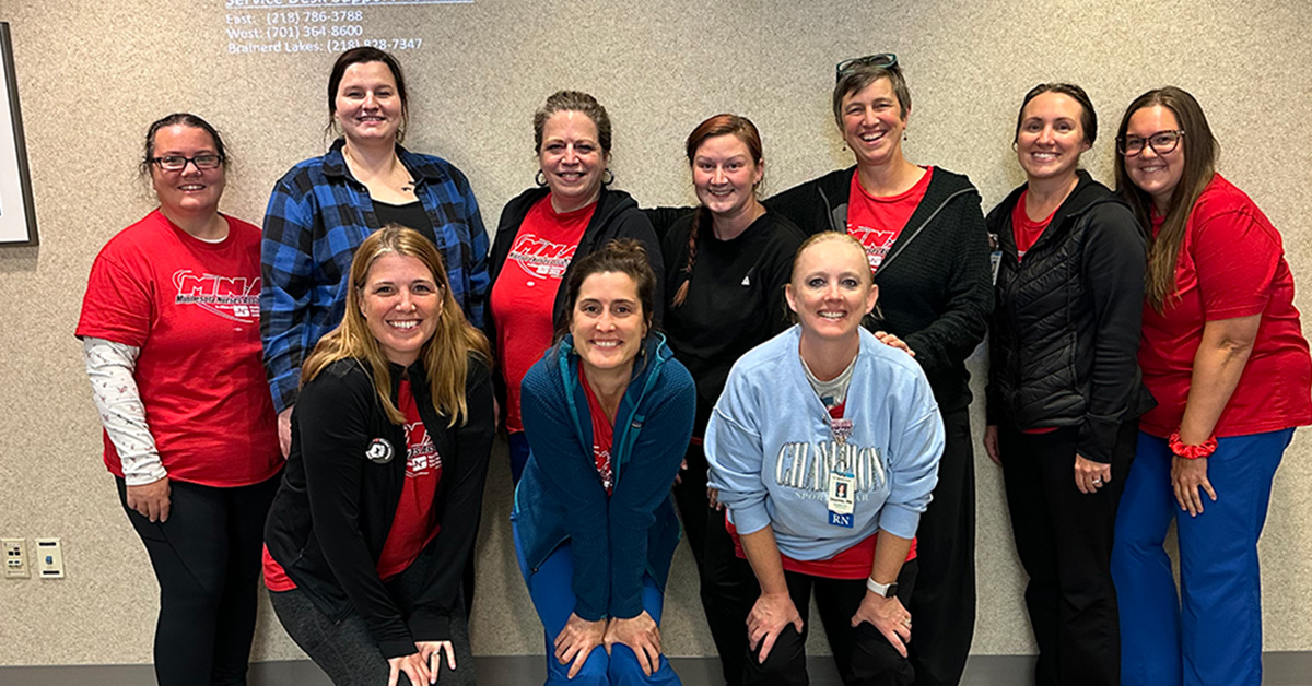 Group of nurses standing side-by-side, in hospital, smiling