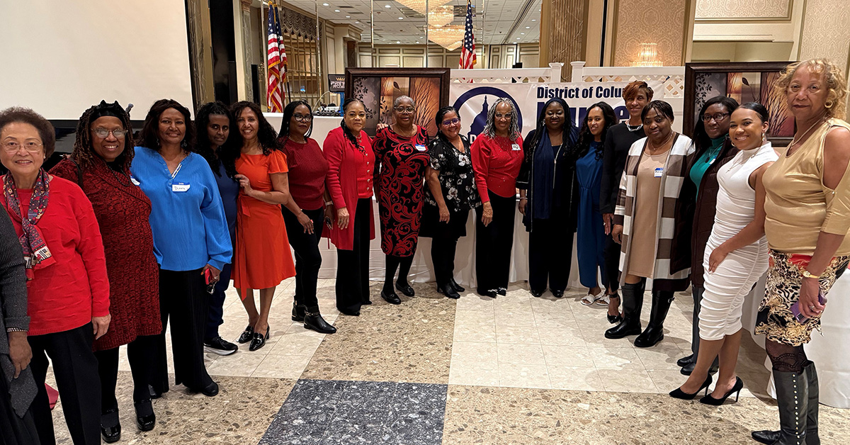 Large group of nurses pose side-by-side in banquet hall