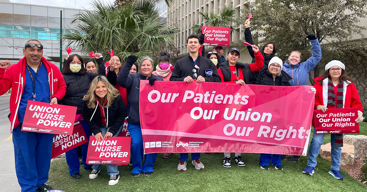 Group of nurses outside, smiling, holding banner "Our Patients, Our Union, Our Rights"