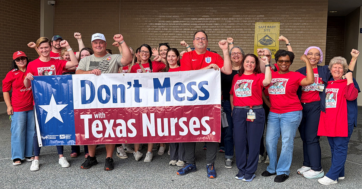 Large group of nurses outside hospital, with raised fists, holding banner "Don't Mess With Texas Nurses"