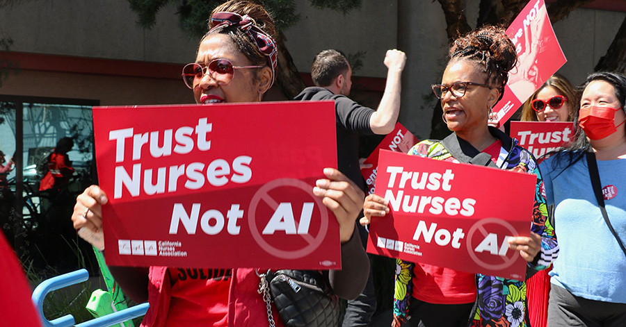 Nurses on picket line hold signs "Trust Nurses, Not A.I."