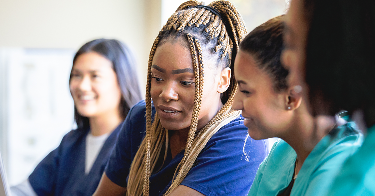 Student nurses looking at work together.