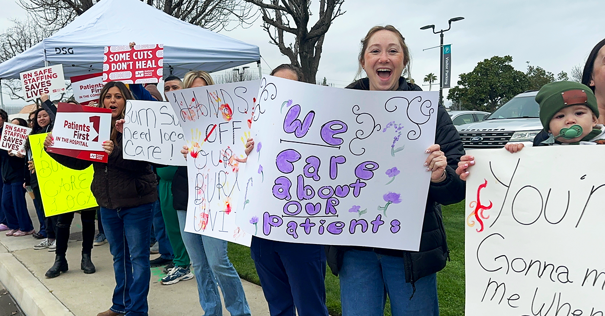 Bakersfield nurses holding signs along street "We care about our patients" "Hands off our burn unit" "Some cuts don't heal"