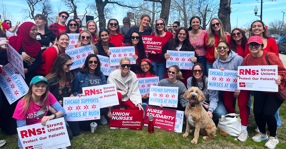Large group of people outside, smiling, holding signs "Chicago Supports Nurses At RUSH"