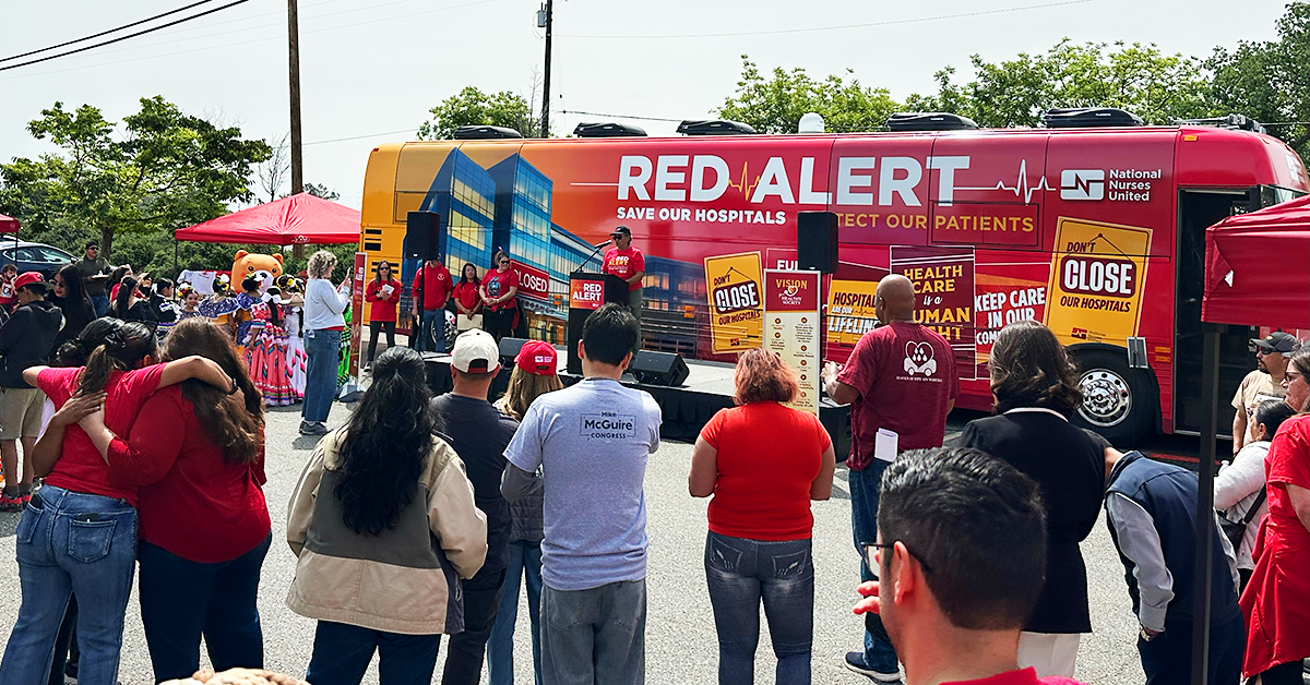 Community at Red Alert Tour stop with red alert bus in background