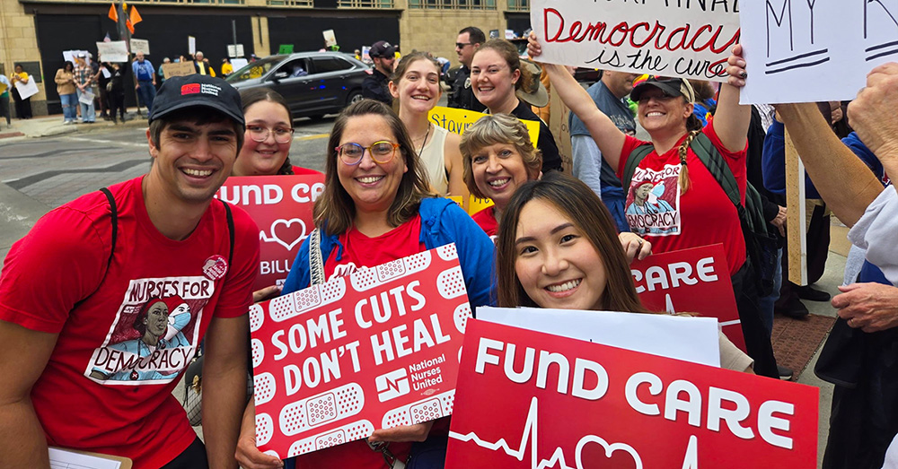 Group of nurses in No Kings march, holding signs "Fund Care, NOT Billionaires"