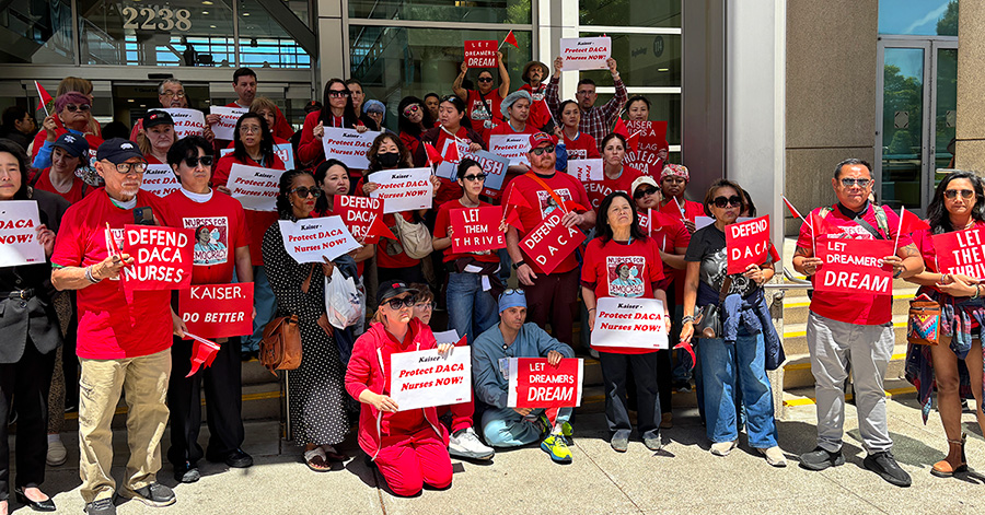 Large group of nurses outside hospital holding signs "Defend DACA Nurses" and "Protect DACA Nurses Now!"