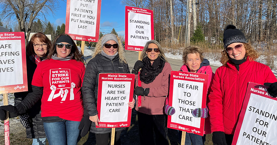 Group of nurses on picket line holding signs