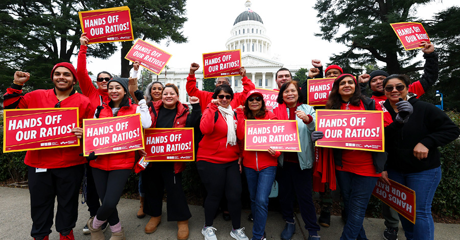 Group of nurses outside California State Capitol building holding signs "Hands Off Our Ratios"