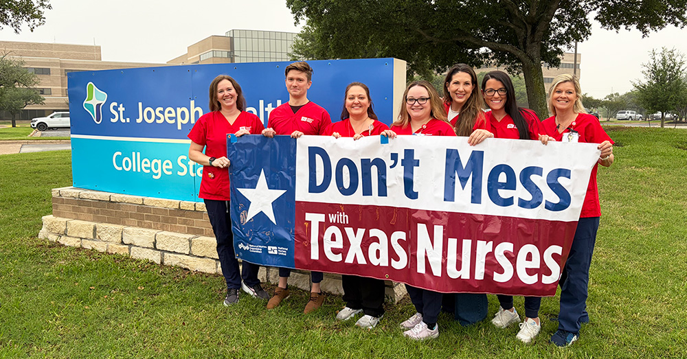 Group of nurses outside St. Joseph Health holding banner "Don't Mess With Texas Nurses"