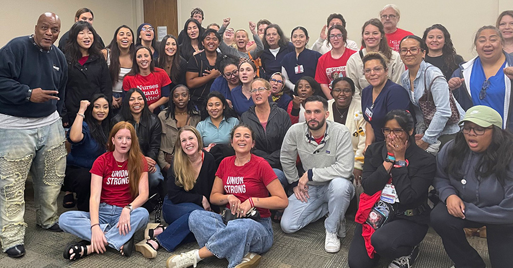 Large group of nurses inside hospital meeting room smiling