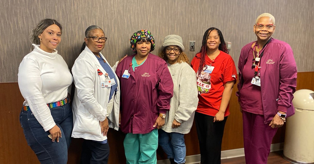 Group of six nurses, side-by-side, smiling