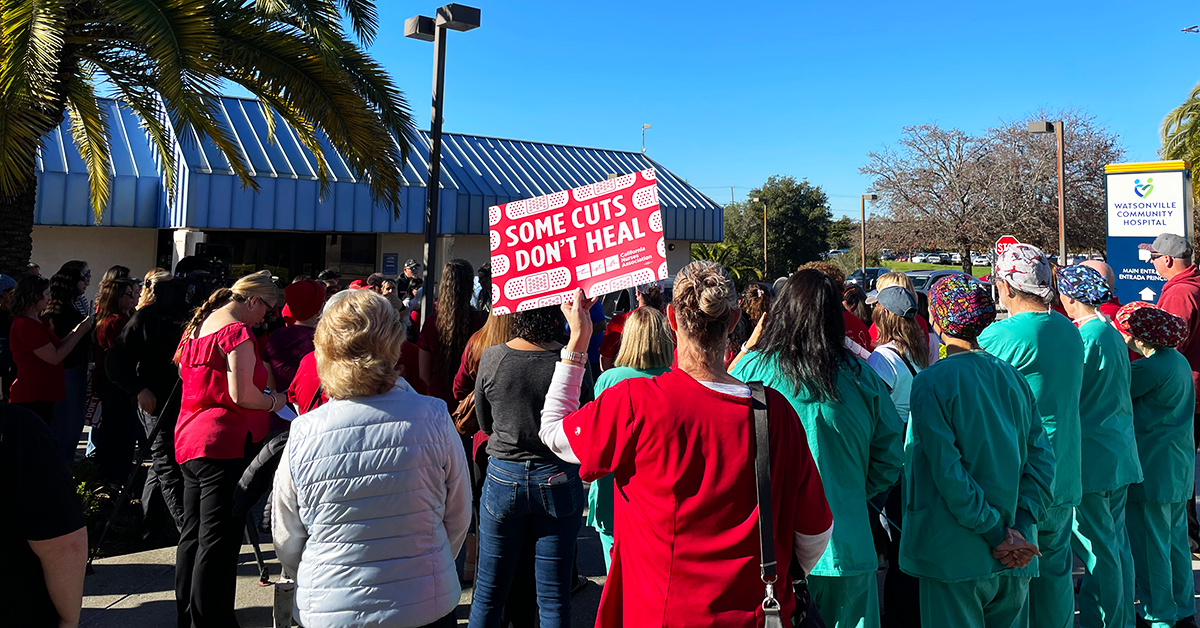 Watsonville nurse, staff, community, holding sign "Some cuts don't heal"