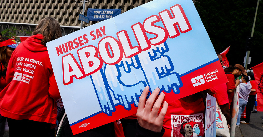 Hand holding signs "Nurses Say Abolish ICE"