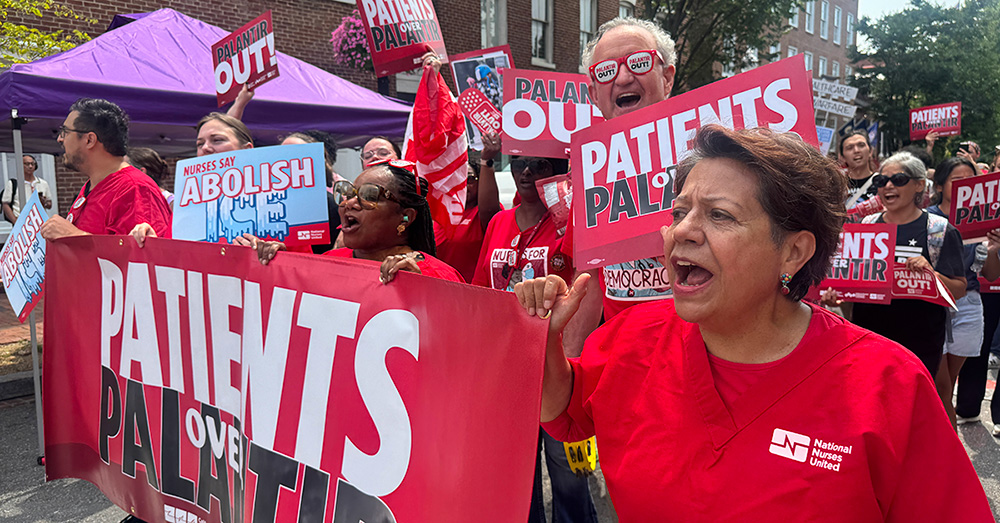 Nurses marching with banner "Patients Over Palantir"