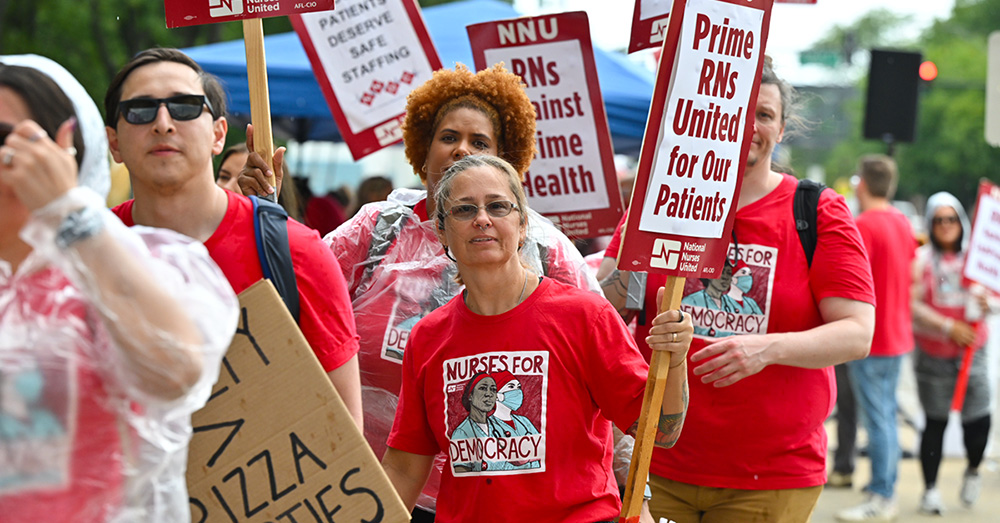 Nurse on picket line holding signs "Prime RNs United for our Patients"