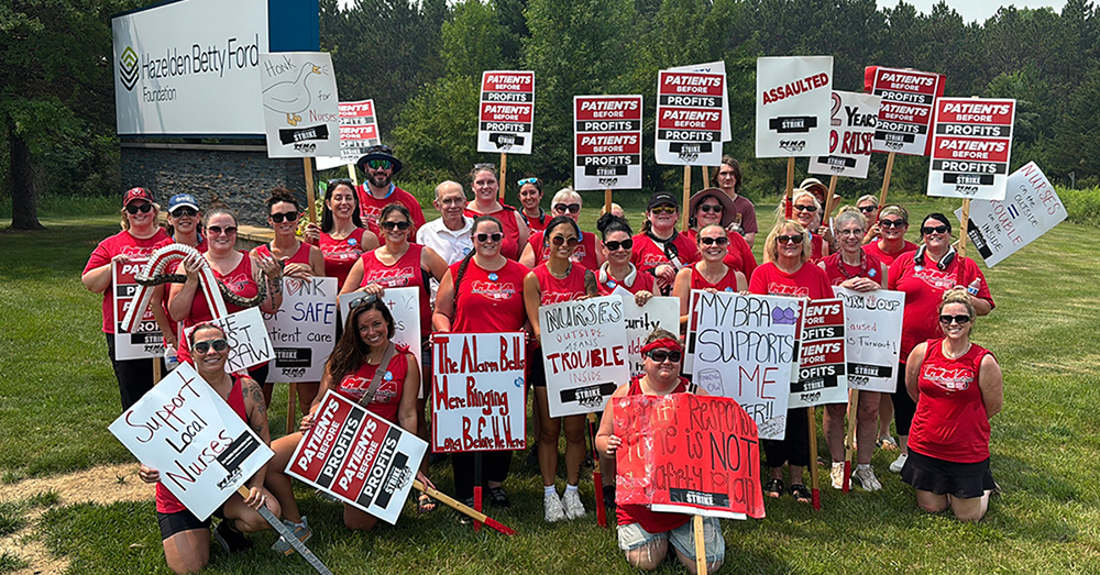 Large group of nurses outside Hazelden Betty Ford  hosptial with picket signs "Patients Before Profits" and more.