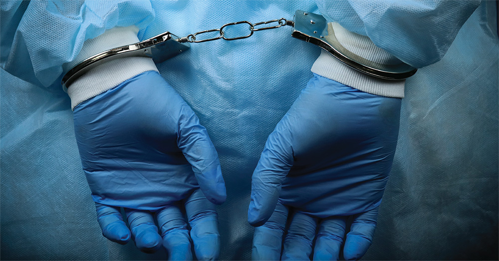 Medical workers hands behind back and in handcuffs