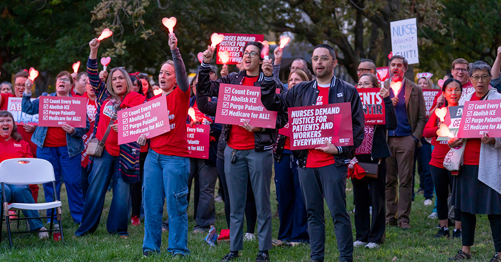 Group of nurses outside, holding lights and signs "Nurses Demand Justice for Patients and Workers Everywhere" and "Count Every Vote"
