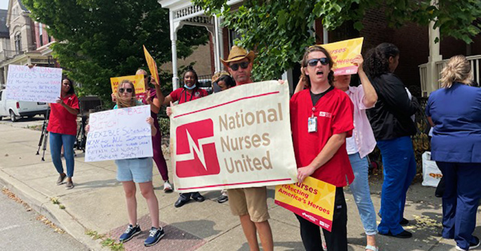 Nurses on picket line holding National Nurses United banner