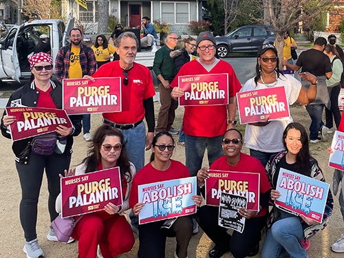 Nurses holding signs "Purge Palantir"