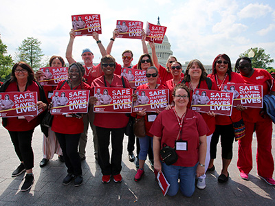 Nurses outside Capitol Building holdiinh signs "Safe Staffing Saves Lives"
