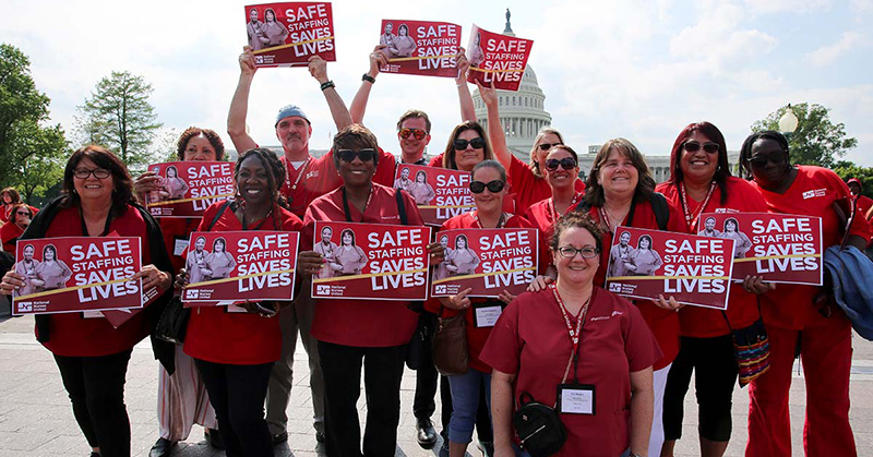 Nurses holding signs "Safe Staffing Saves Lives"