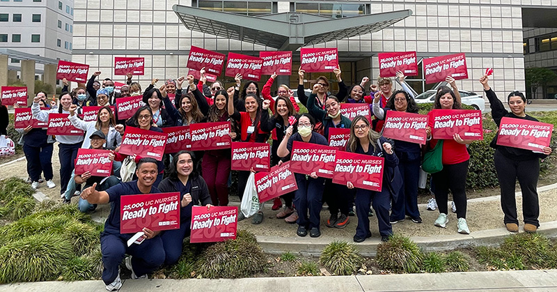 Large group of nurses outside holding signs "Ready to Fight"