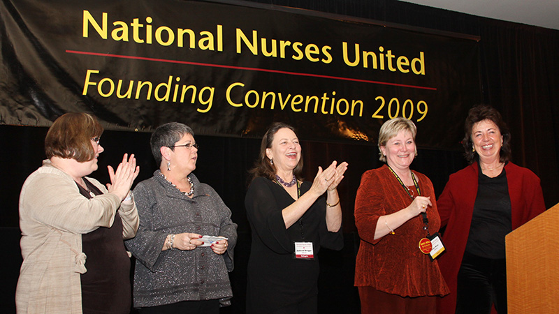 Nurses at convenion table clapping