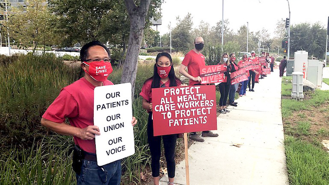 Nurses hold signs