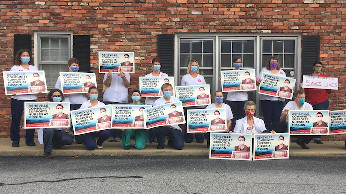 Mission nurses hold signs on community support