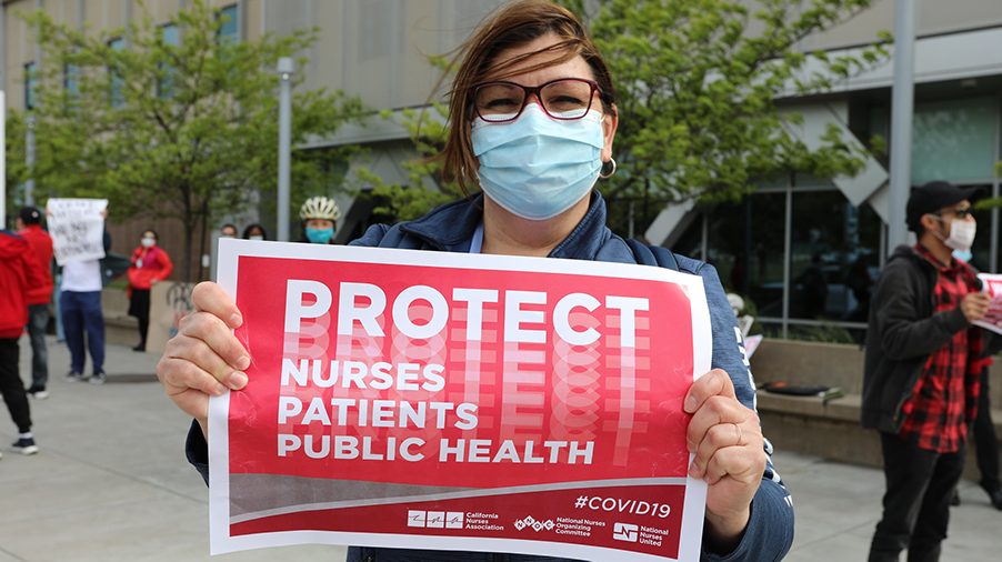 Nurse holds sign "Protect Nurses, Patients, Public Health"