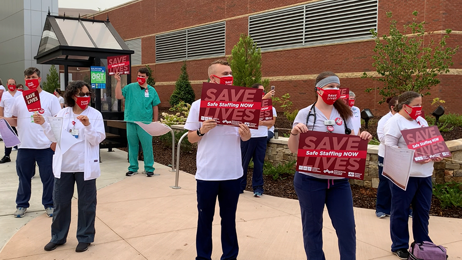 Nurses at HCA’s Mission Hospital hold signs for safe staffing and optimal PPE