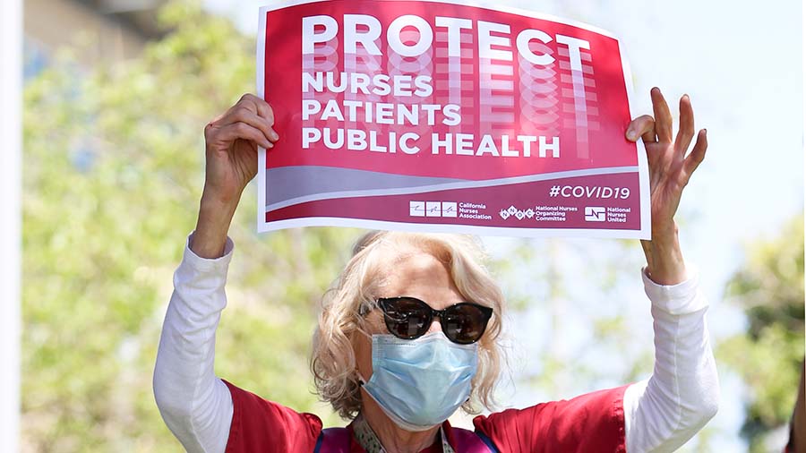Nurse holding sign "Protect Nurses, Patients, Public Health"