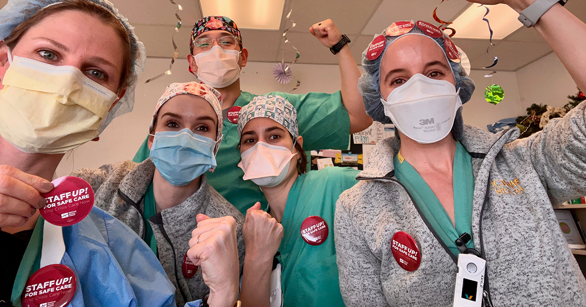 UC Davis nurses with fists raised and stickers "Staff up for safe care. End crisis care now"