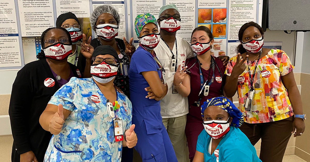 Group of nurses inside hospital giving thumbs up