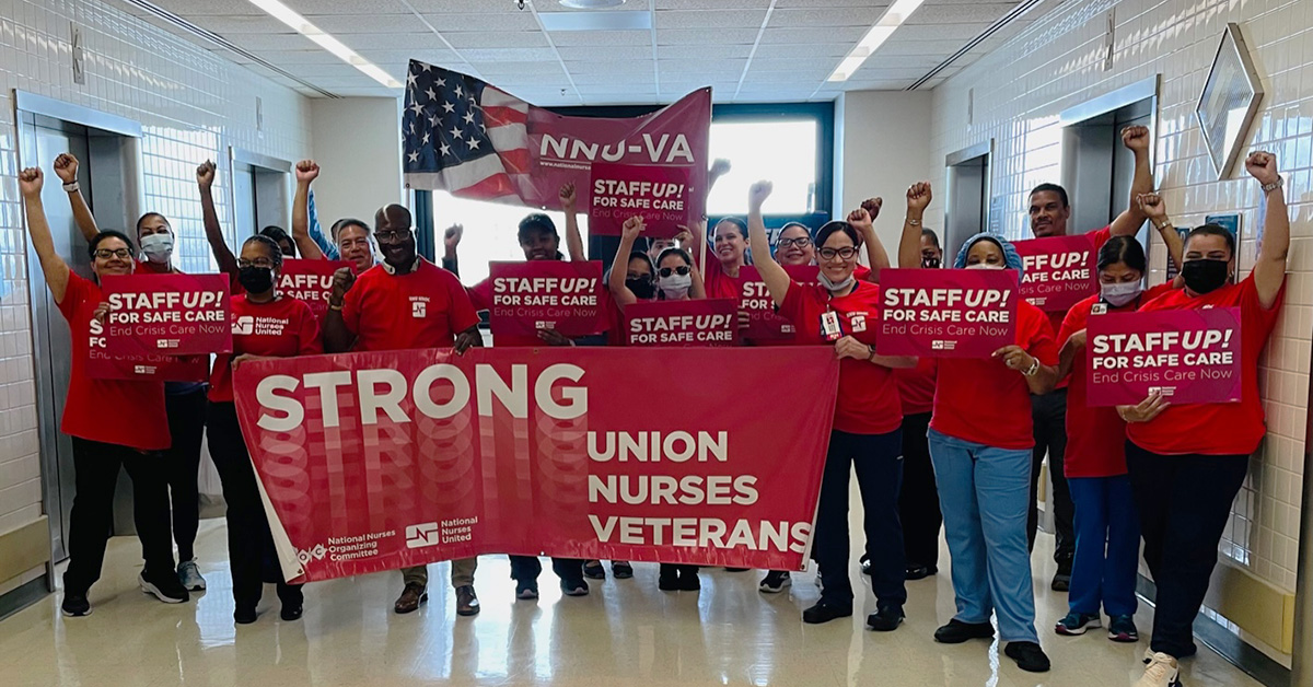Large group of nurses inside hospital, holdig banner "Strong Union, Nurses, Veterans" and signs "Staff Up for Safe Care"