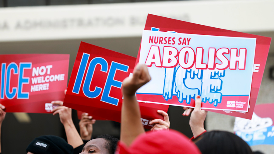 Hands holding signs "ICE not welcome here" and "Abolish ICE"