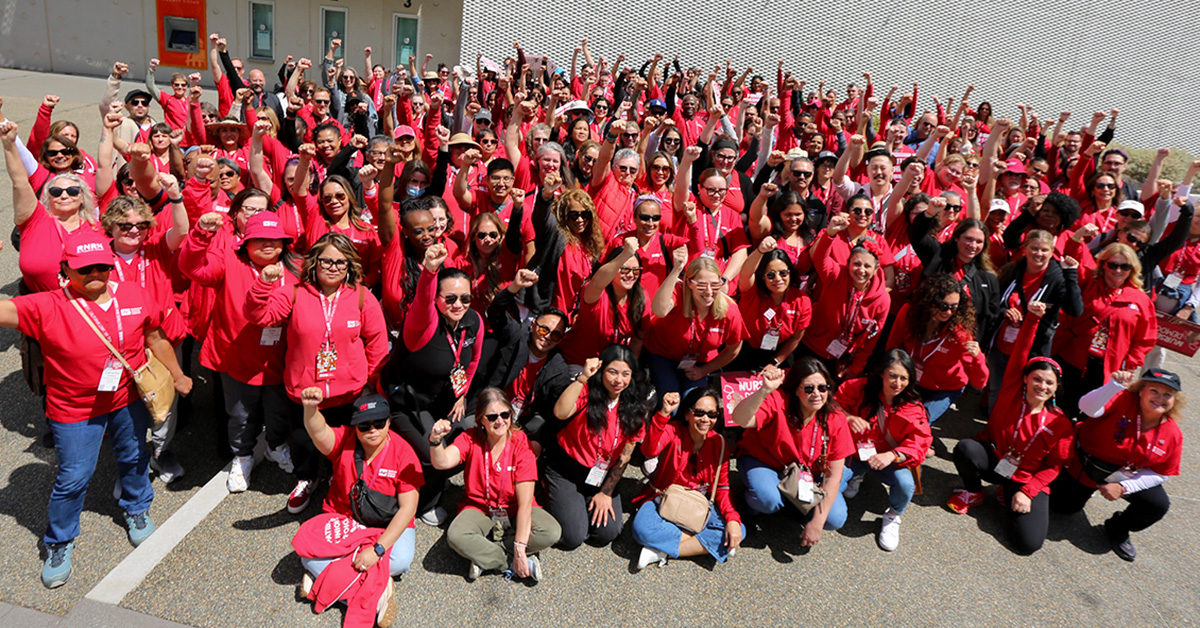 Large group of nurses with raised fists